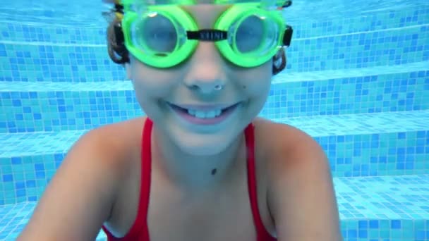 Glückliches Mädchen in Schutzbrille schwimmt unter Wasser — Stockvideo