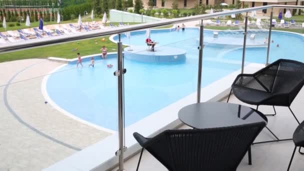 Piscinas con personas descansando y terraza con sillas — Vídeos de Stock