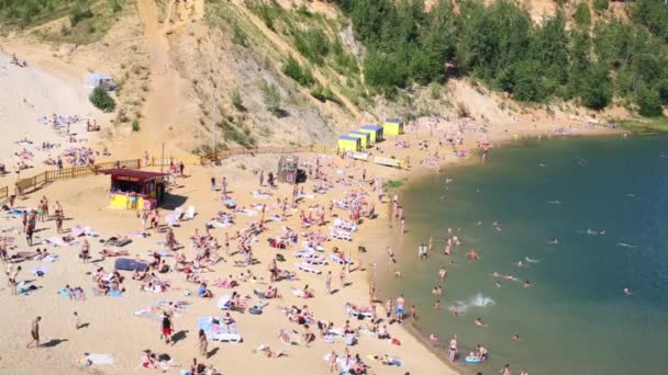 Pessoas tomar banho de sol e relaxar na praia arenosa — Vídeo de Stock