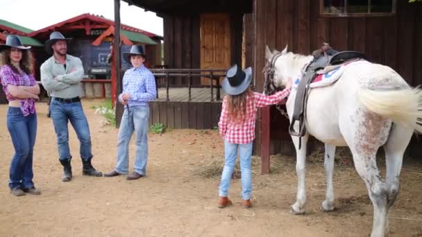 Familia de vaqueros se levanta en la plaza contra los pabellones comerciales — Vídeos de Stock