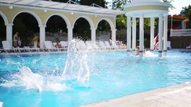 Menino salta para piscina com jacuzzi — Vídeo de Stock