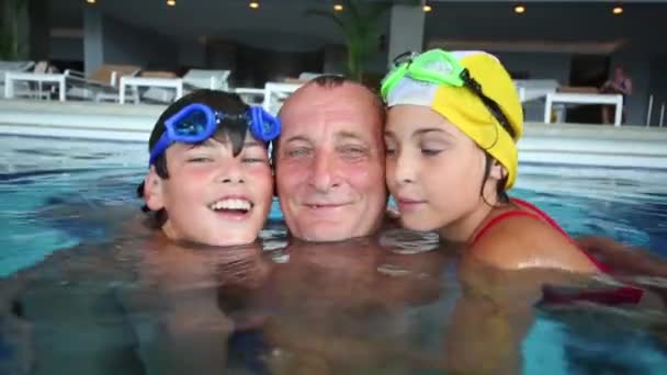 Grootvader en kinderen in zwembad — Stockvideo
