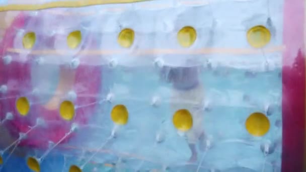 Fille court dans le grand cylindre gonflable sur l'eau — Video