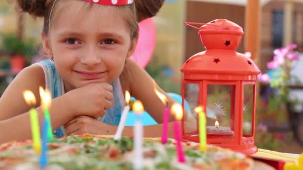 Little girl looks at pizza with candles — Stock Video