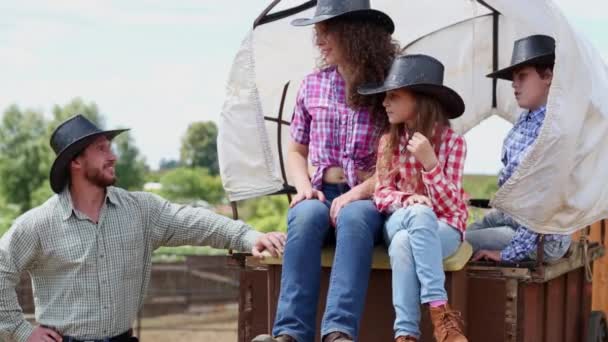 Cowboy familie zit op de wagen, dan begint om uitstappen — Stockvideo