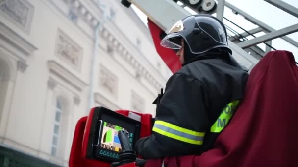 Bombero mira hacia arriba en escalera — Vídeo de stock