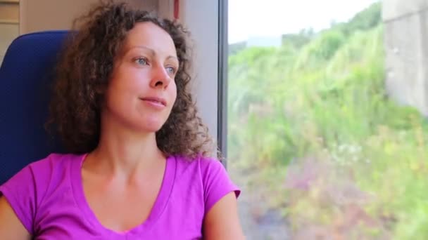 Beautiful woman looks at window of train — Stock Video