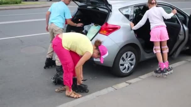 Family on roller skates near the car before skating — Stock Video