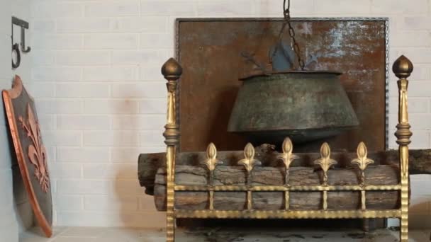 Medieval chimney with hanging metal boiler and logs — Stock Video