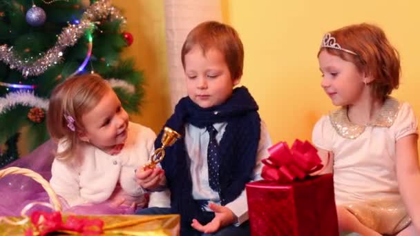 Drei Kinder in der Nähe des Weihnachtsbaums — Stockvideo