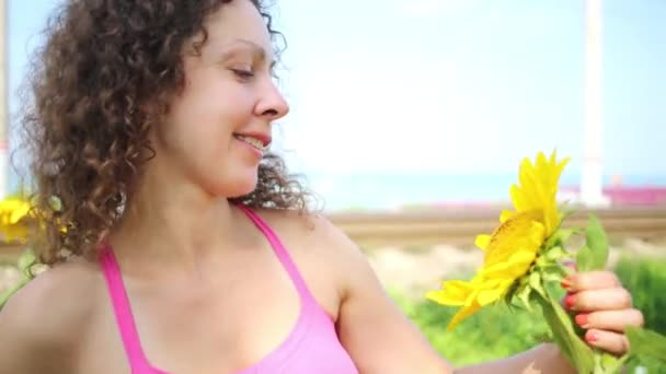 Bella donna guarda girasole — Video Stock