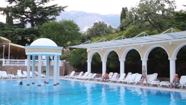 La gente descansa cerca de piscina abierta — Vídeos de Stock