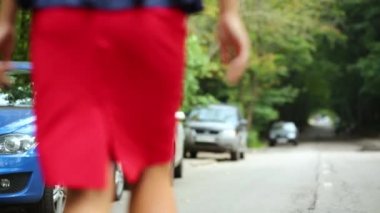 Kız yoluna park edilmiş arabalar ile yol boyunca gider.