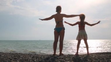 Anne ve kızı sidewards genişletilmiş kollu