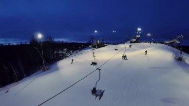 Işıklı kar yamaç insanlar ve teleferik 
