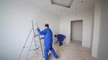 işçiler, bir oda tadilatı bir merdiven koyar 