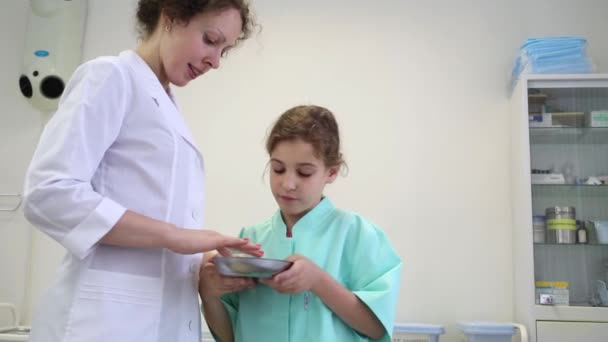 Chica y médico mirando en cuenco de metal — Vídeos de Stock