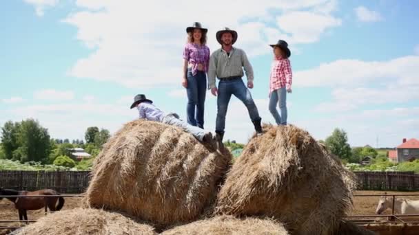 カウボーイ家族が乾燥した干し草の俵の上に立つ — ストック動画