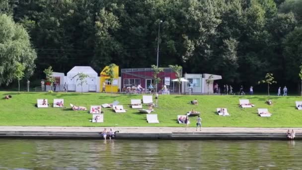 Embankment with sunbathing people — Stock Video