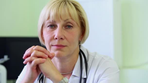 Médica feminina senta-se no local de trabalho — Vídeo de Stock
