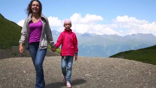 Mujer e hija caminan entre montañas — Vídeo de stock