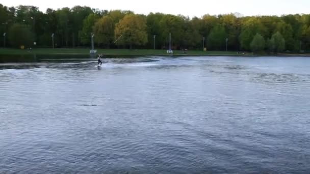 Wakeboarder slides on board at pond — Stock Video