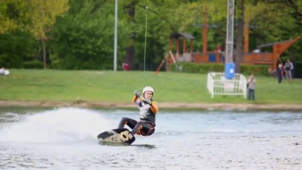 Wakeboarder выполняет трюки на борту — стоковое видео