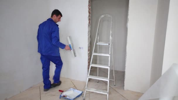 Worker spends by spatula on the wall in the room during the repair — Stock Video