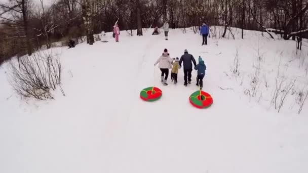 Familie gerund door sneeuw helling — Stockvideo