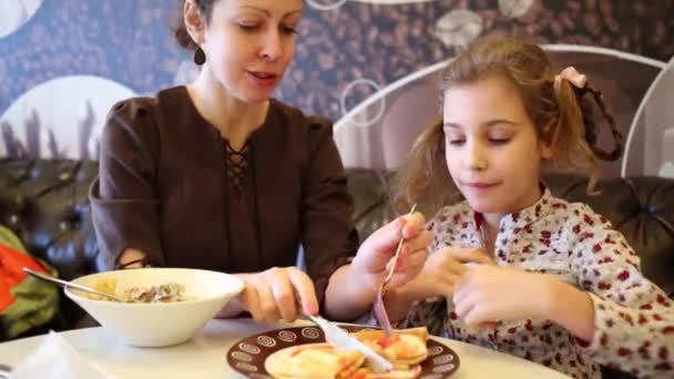 Madre ayuda a la pequeña hija a comer — Vídeos de Stock