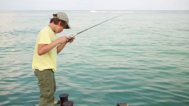 Boy pulls fishing line — Stock Video