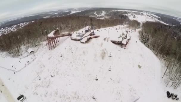 Снежный склон с людьми и подъемником — стоковое видео