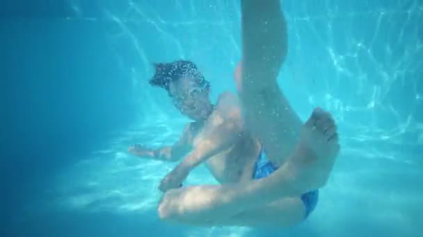 Jongen in bril zwemt onder water — Stockvideo