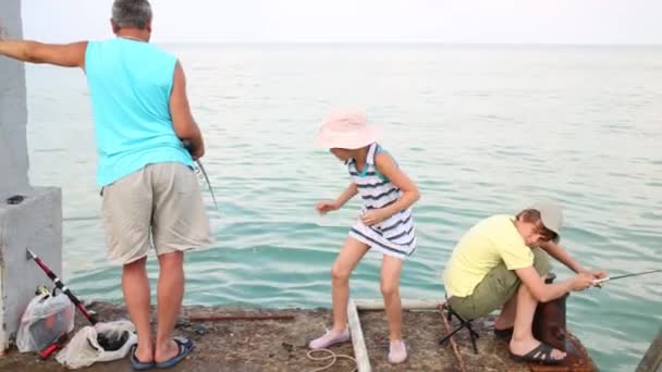 Człowiek z wnukami, wędkowanie na betonowe molo — Wideo stockowe