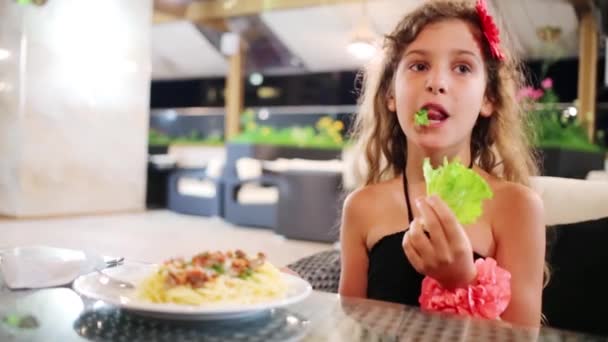 Küçük kız marul restoranda yiyor. — Stok video