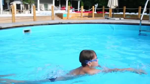 Kleiner Junge in Schutzbrille schwimmt — Stockvideo