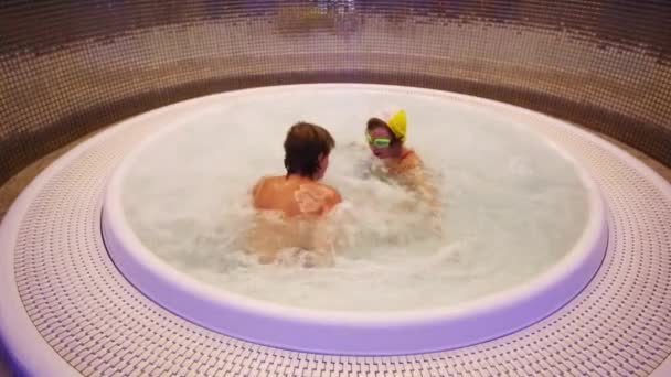 Boy and girl play in round jacuzzi — Stock Video