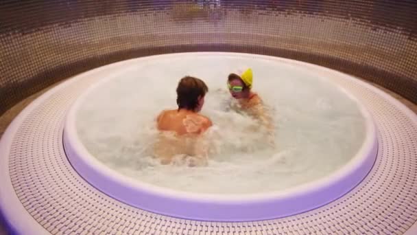 Jongen en meisje spelen in ronde jacuzzi — Stockvideo