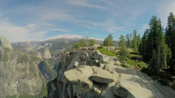 Man staat op de top van rotsachtige berg — Stockvideo