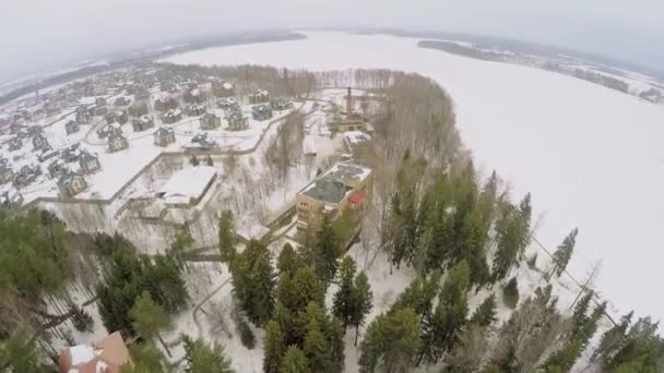 Villaggio vicino foresta e fiume innevato — Video Stock