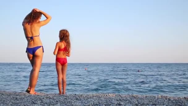 Mother with daughter in swimsuits standing on beach — Stock Video