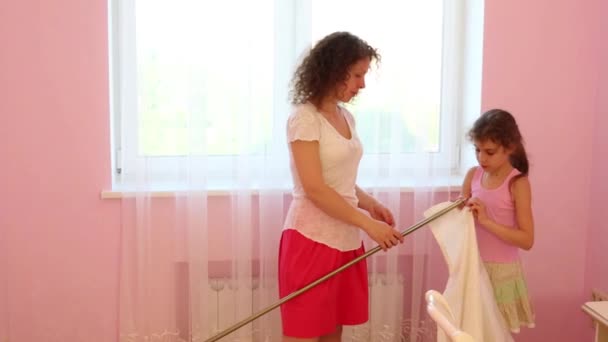 Mother and daughter prepare curtain for hanging in room — Stock Video