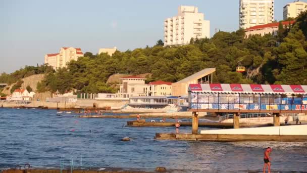 Ligne côtière et jetées et personnes au repos — Video