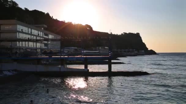 Muelles de hormigón y personas nadando en el mar — Vídeo de stock