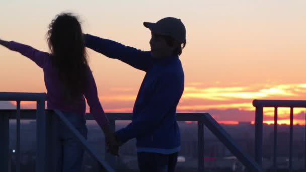 Menino e menina olhando para o pôr do sol — Vídeo de Stock