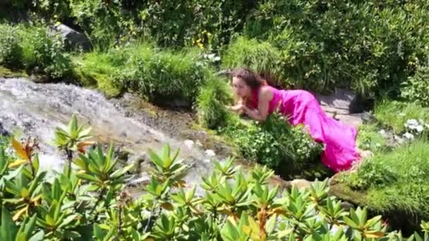 Woman in dress drinks water in mountains — Stock Video