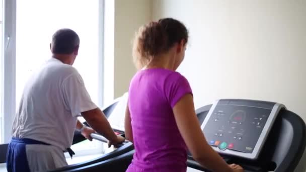 Vrouw en man trein op loopbanden — Stockvideo