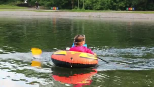 Niño y niña flotando en barco en el lago — Vídeo de stock