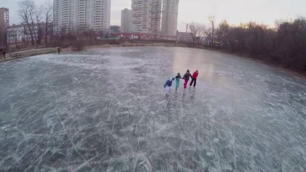 Vier kinderen schaatsen op ijzige vijver — Stockvideo