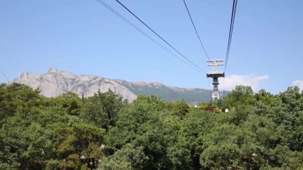 Teleférico sobre la ciudad cerca de la montaña — Vídeos de Stock